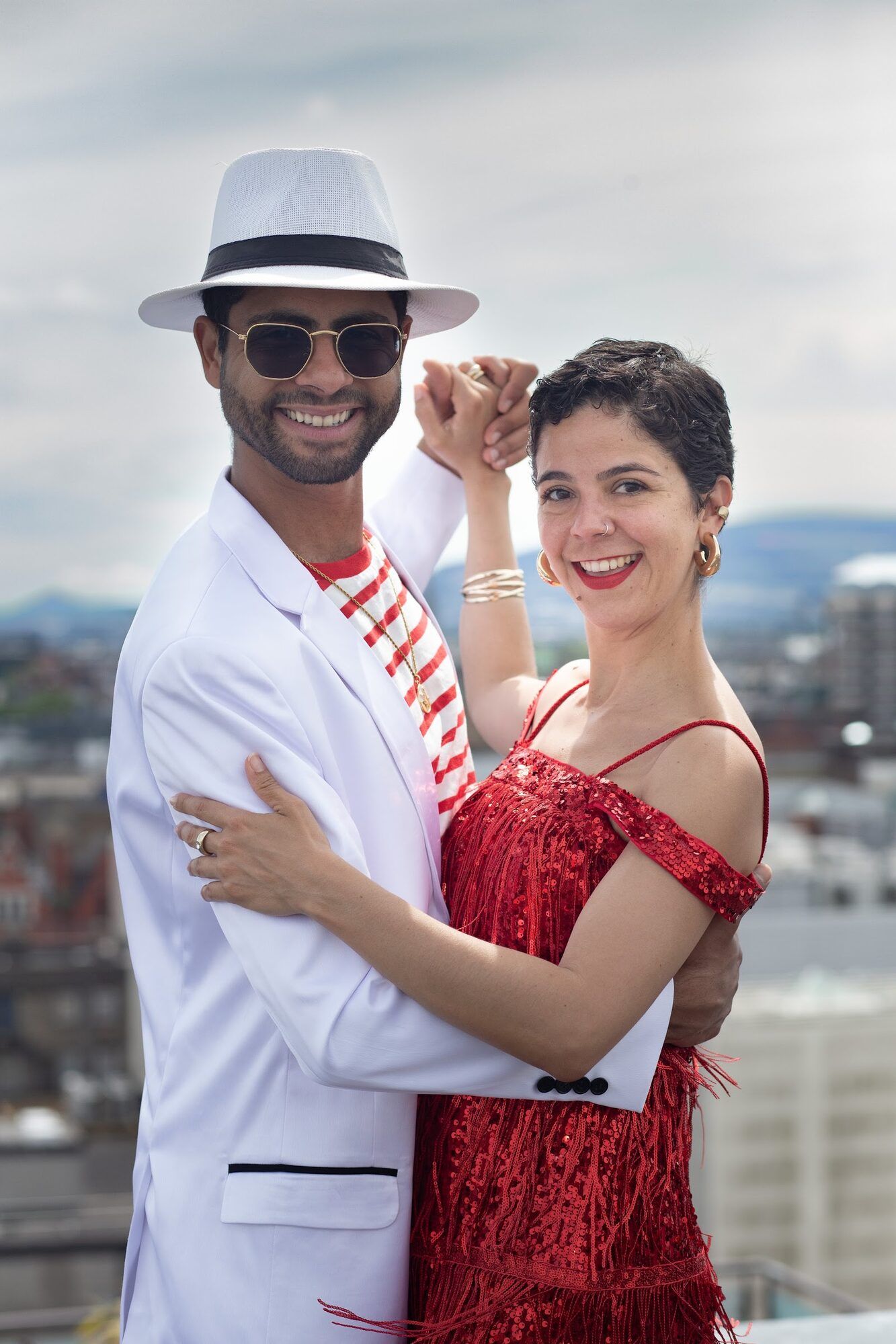 The two dancers cheek to cheek, city roofs behind