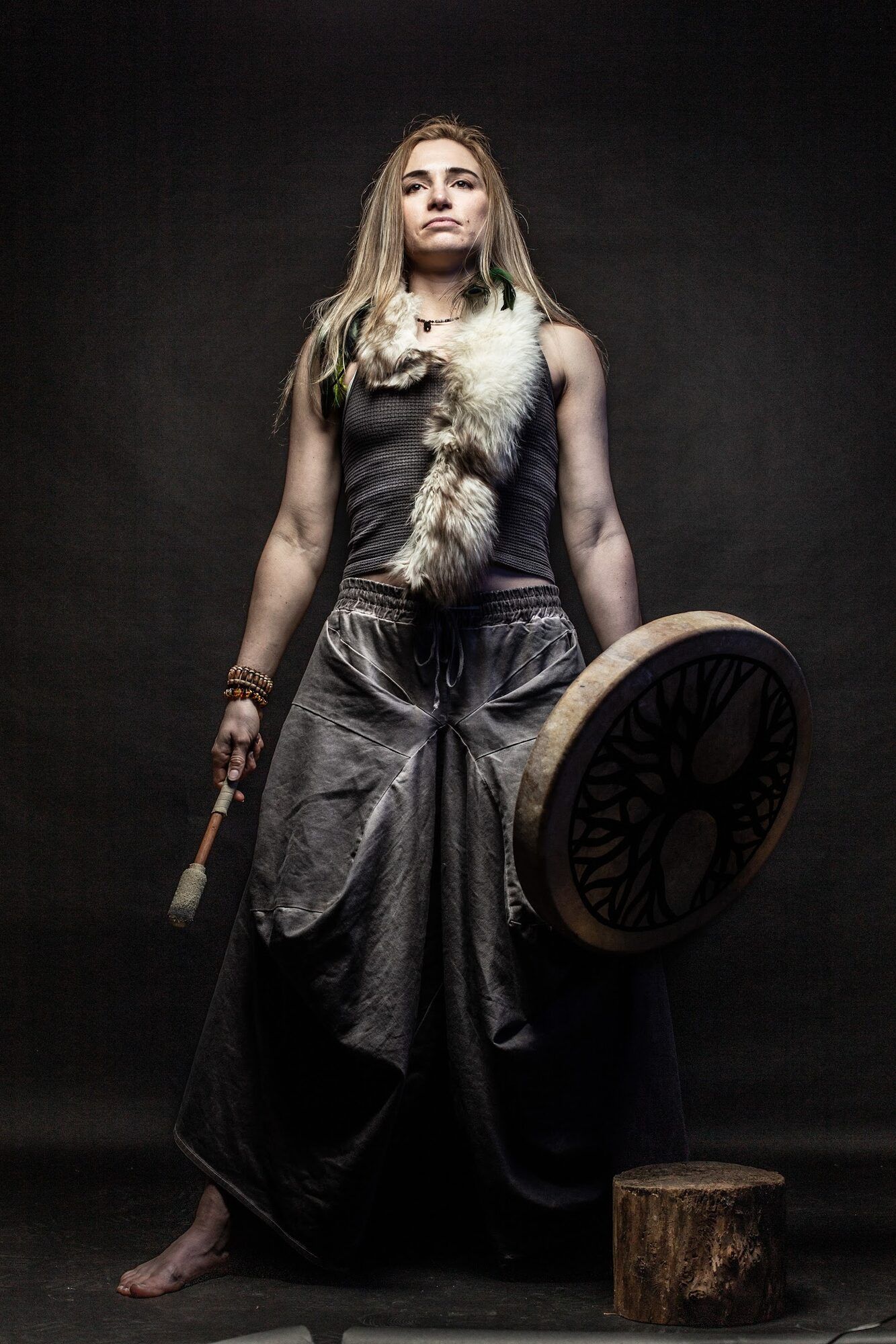 Woman dressed as a warrior with a frame drum, barefoot