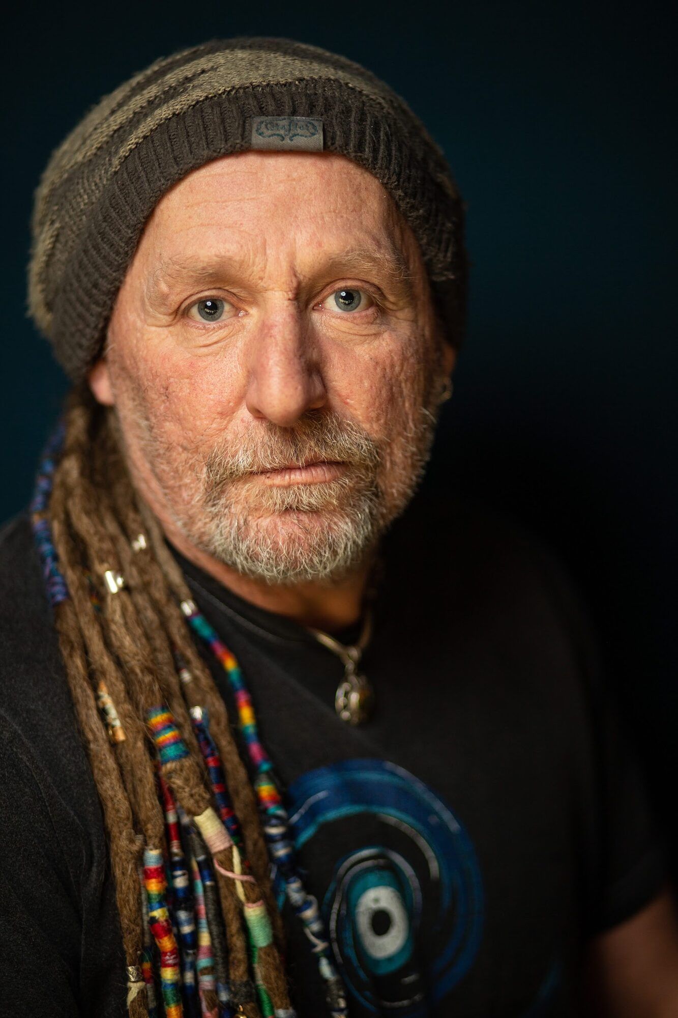 Older man with beaded dreadlocks and a grey beanie