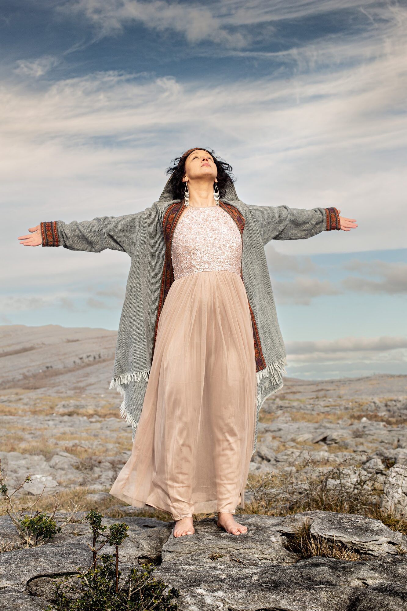 Woman with her arms open wide on bare limestone