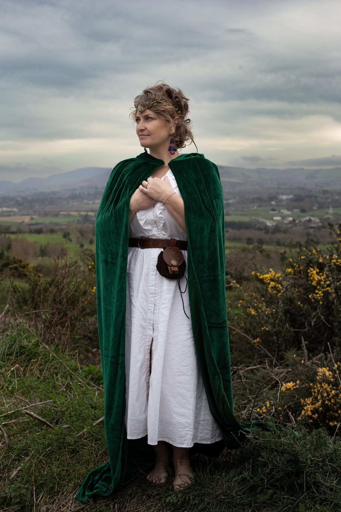 Woman in a green velvet cloak in the hills