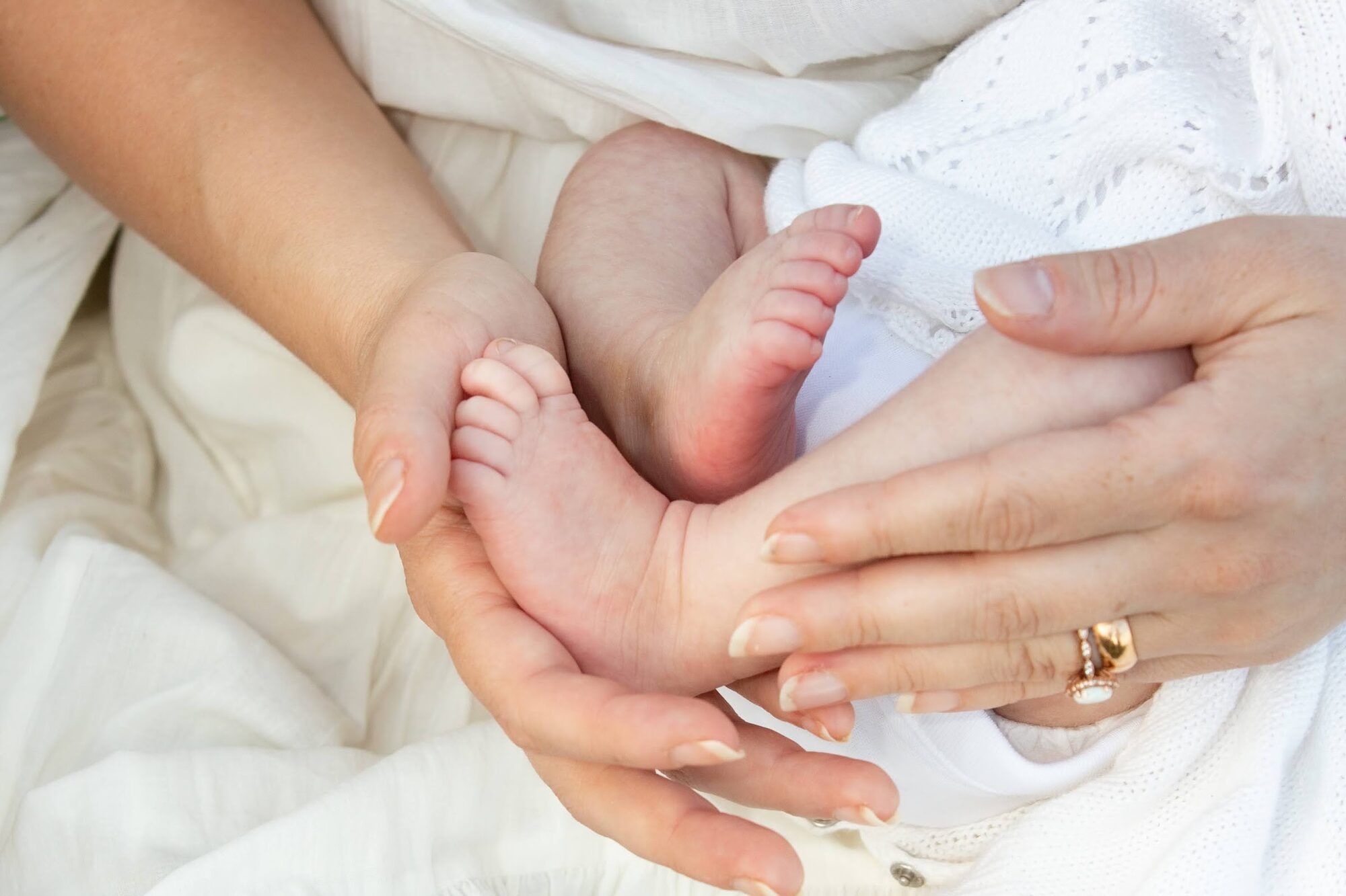 Close-up of a newborn’s feet in a parent’s hands