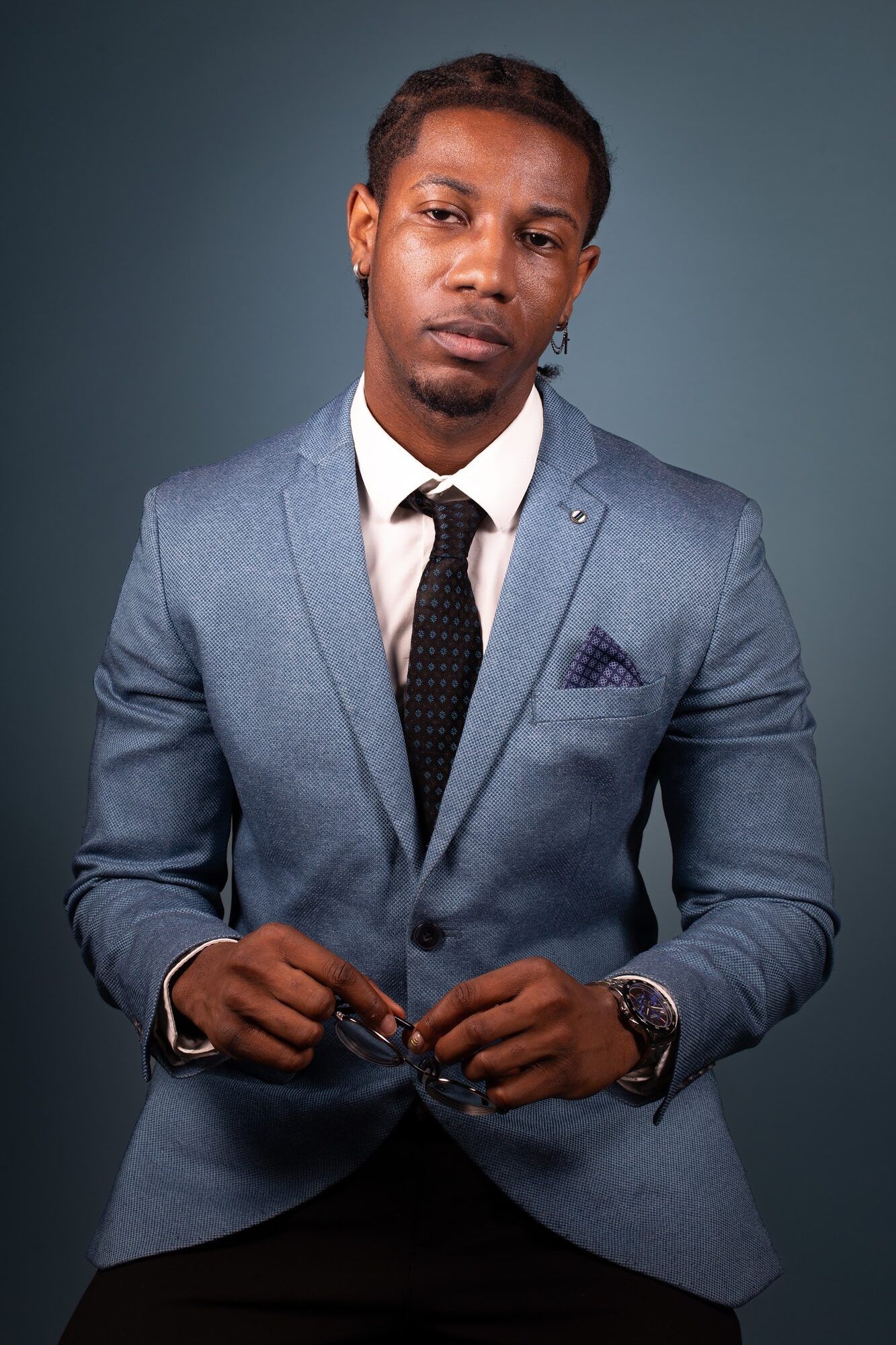 Man in a light blue suit, blue-grey backdrop