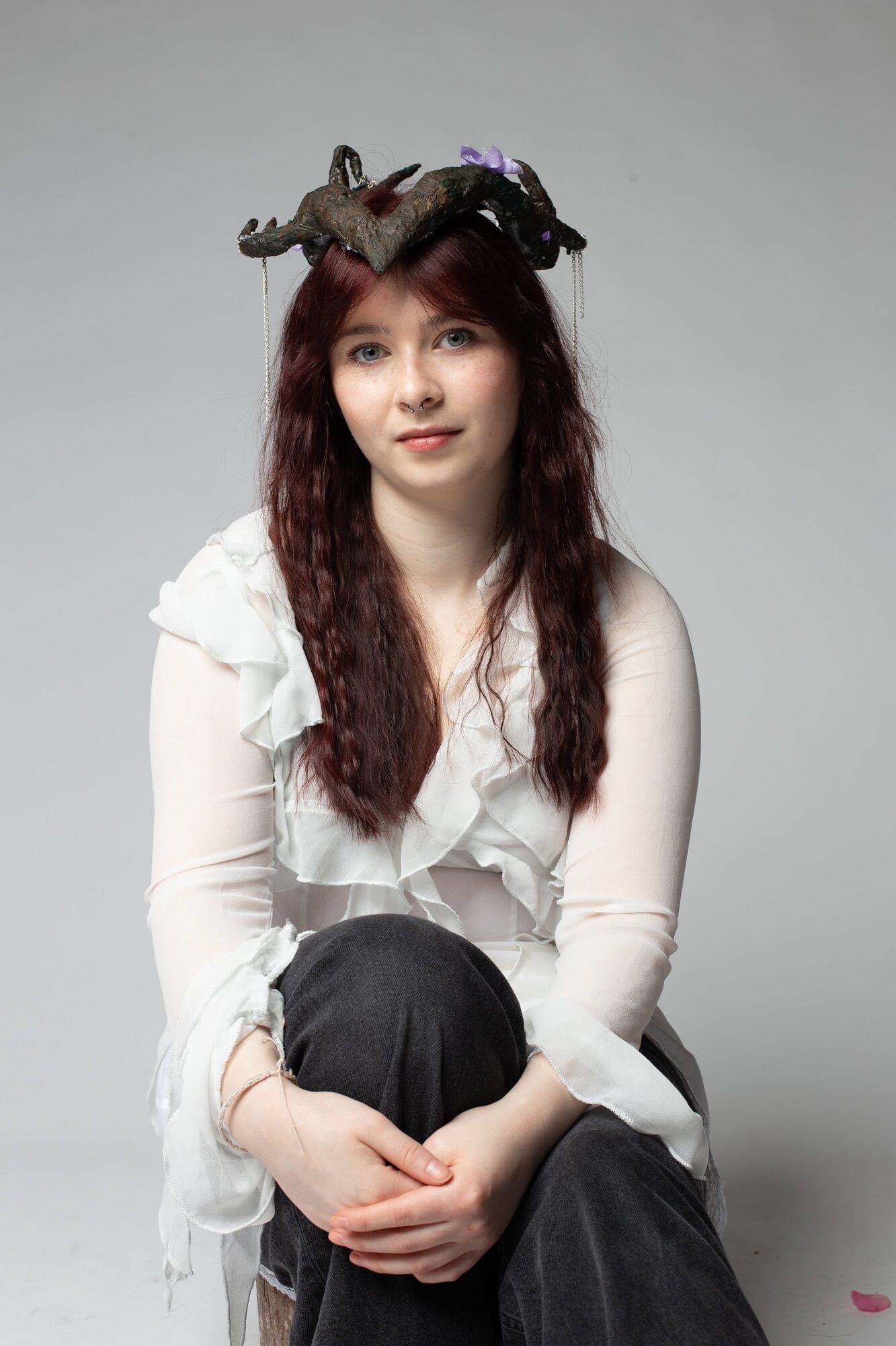 Young woman in a horned headpiece, seated