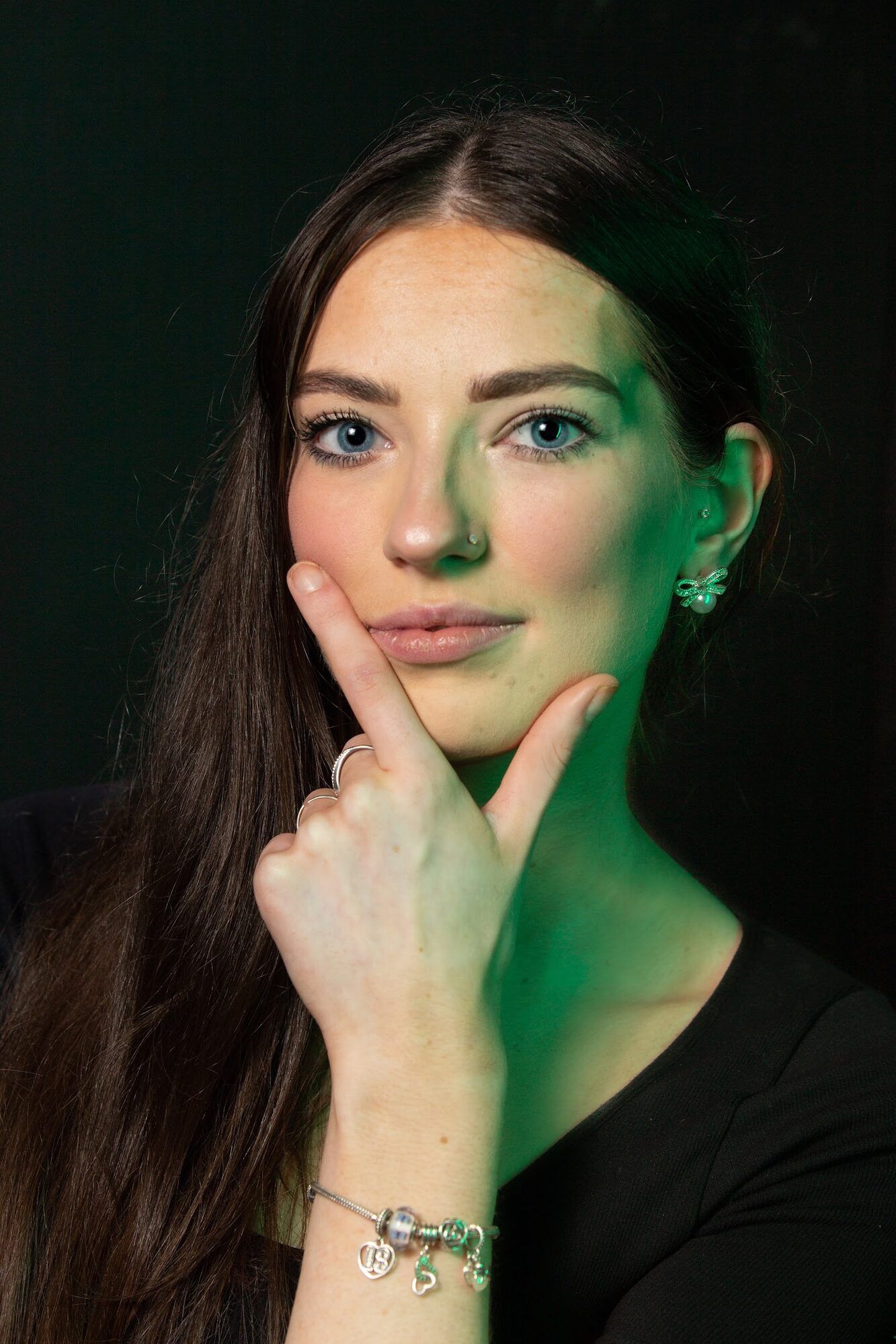 Young woman with a finger at her chin, green light