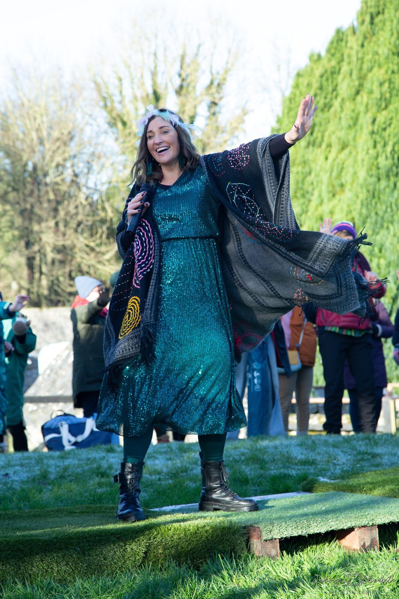 Woman in a teal dress dancing on the grass