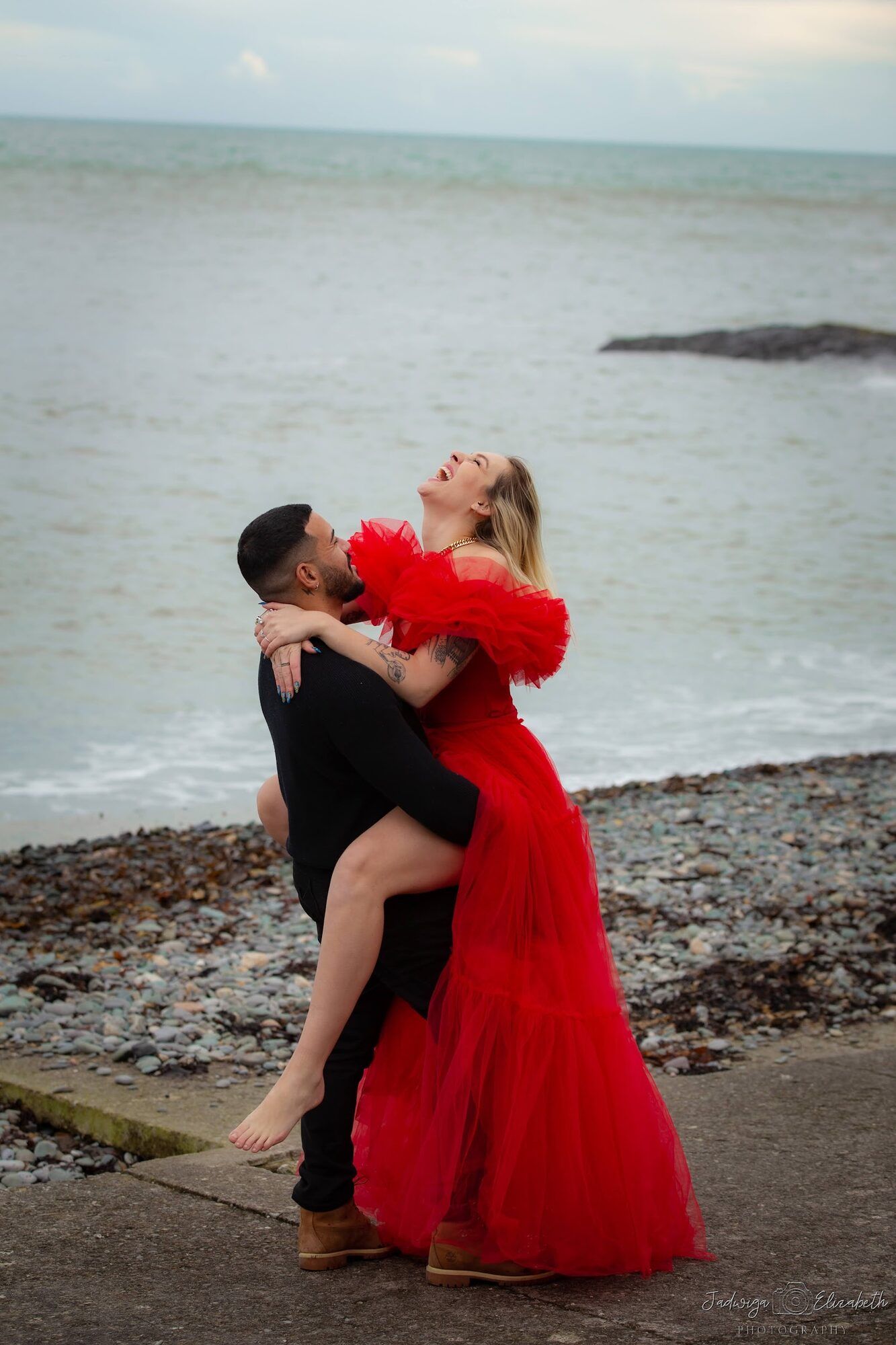 He lifts her on the shore, red gown