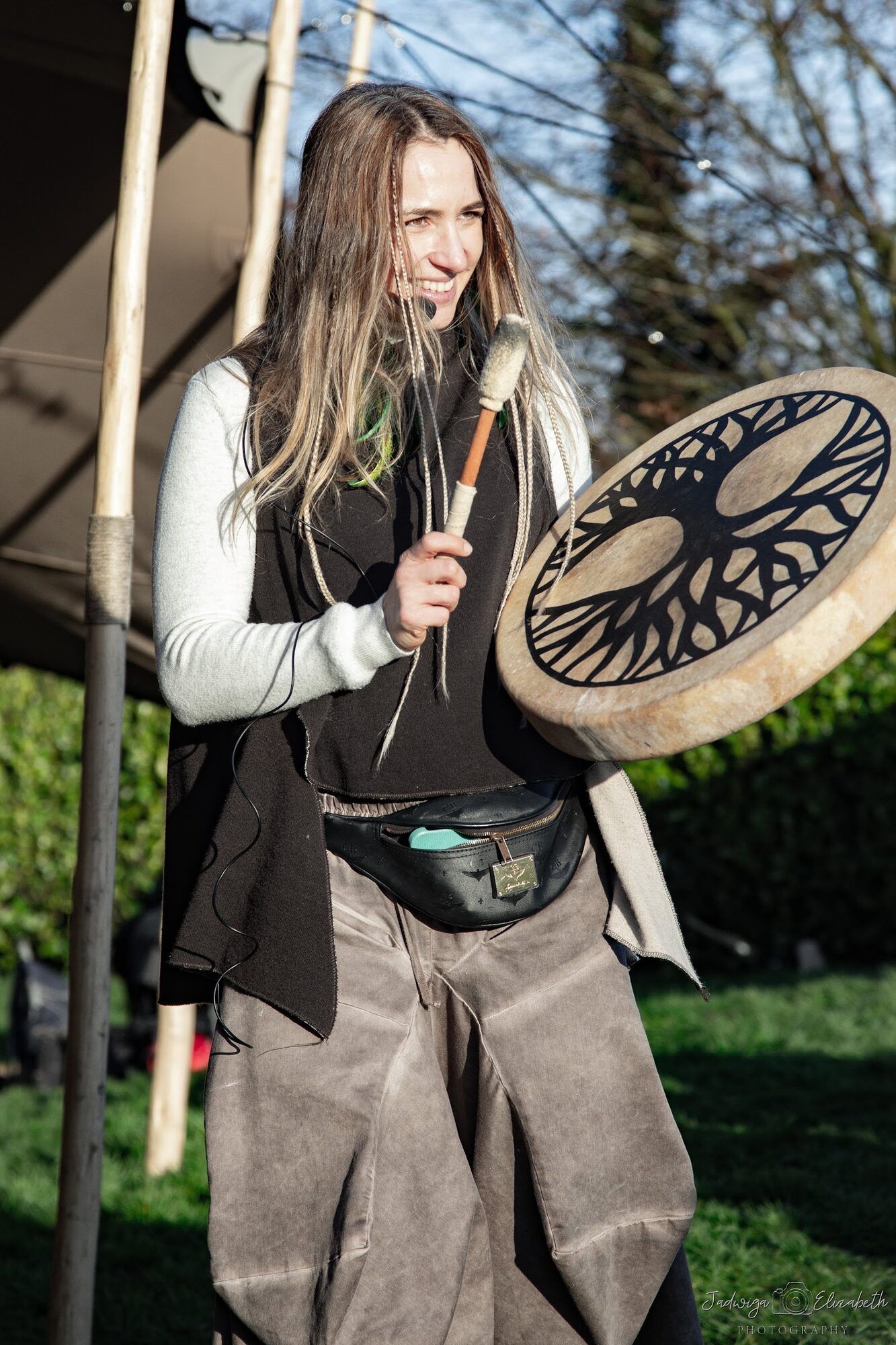 Woman playing a frame drum outdoors