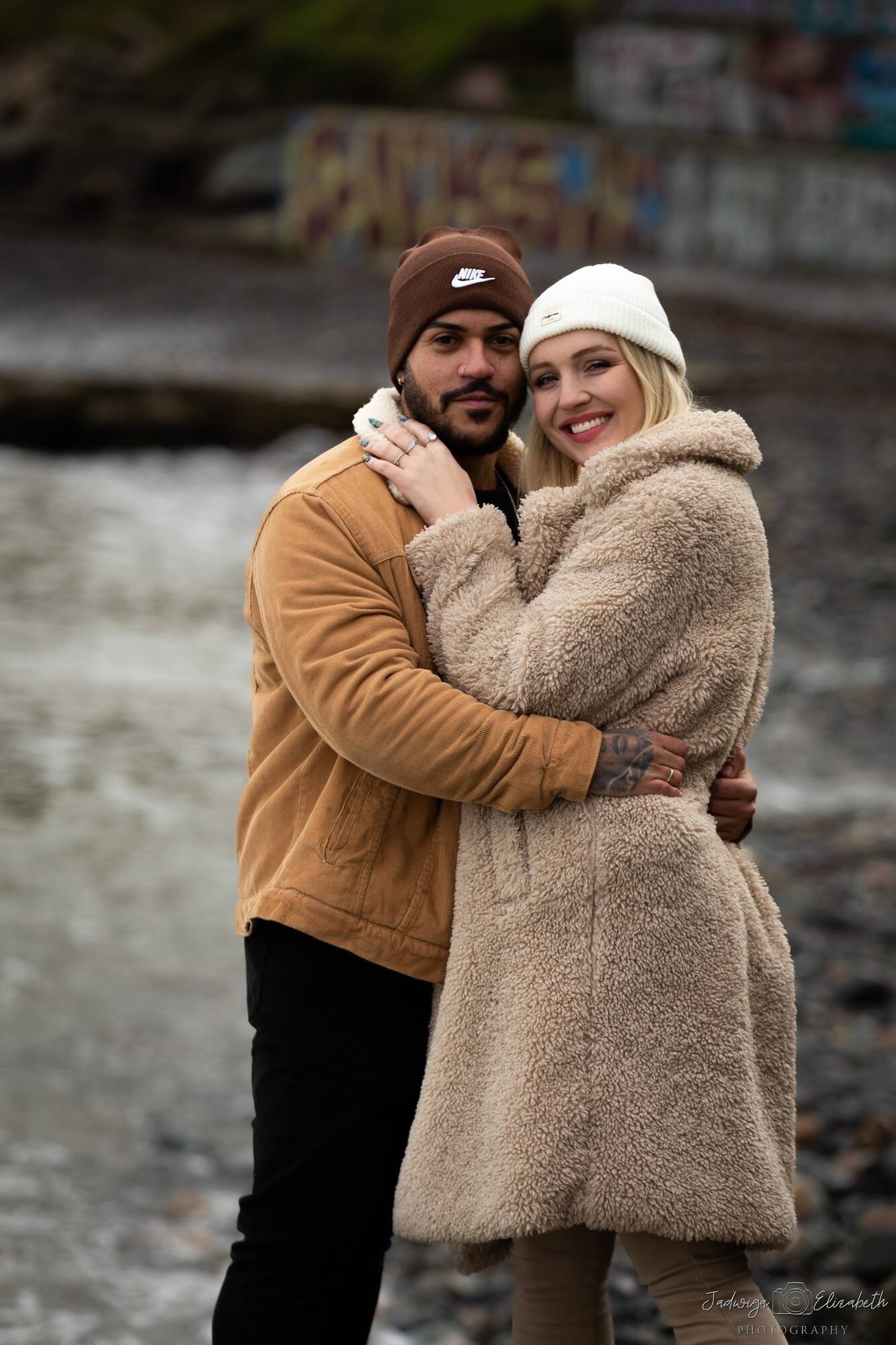 The same couple laughing, woolly hats