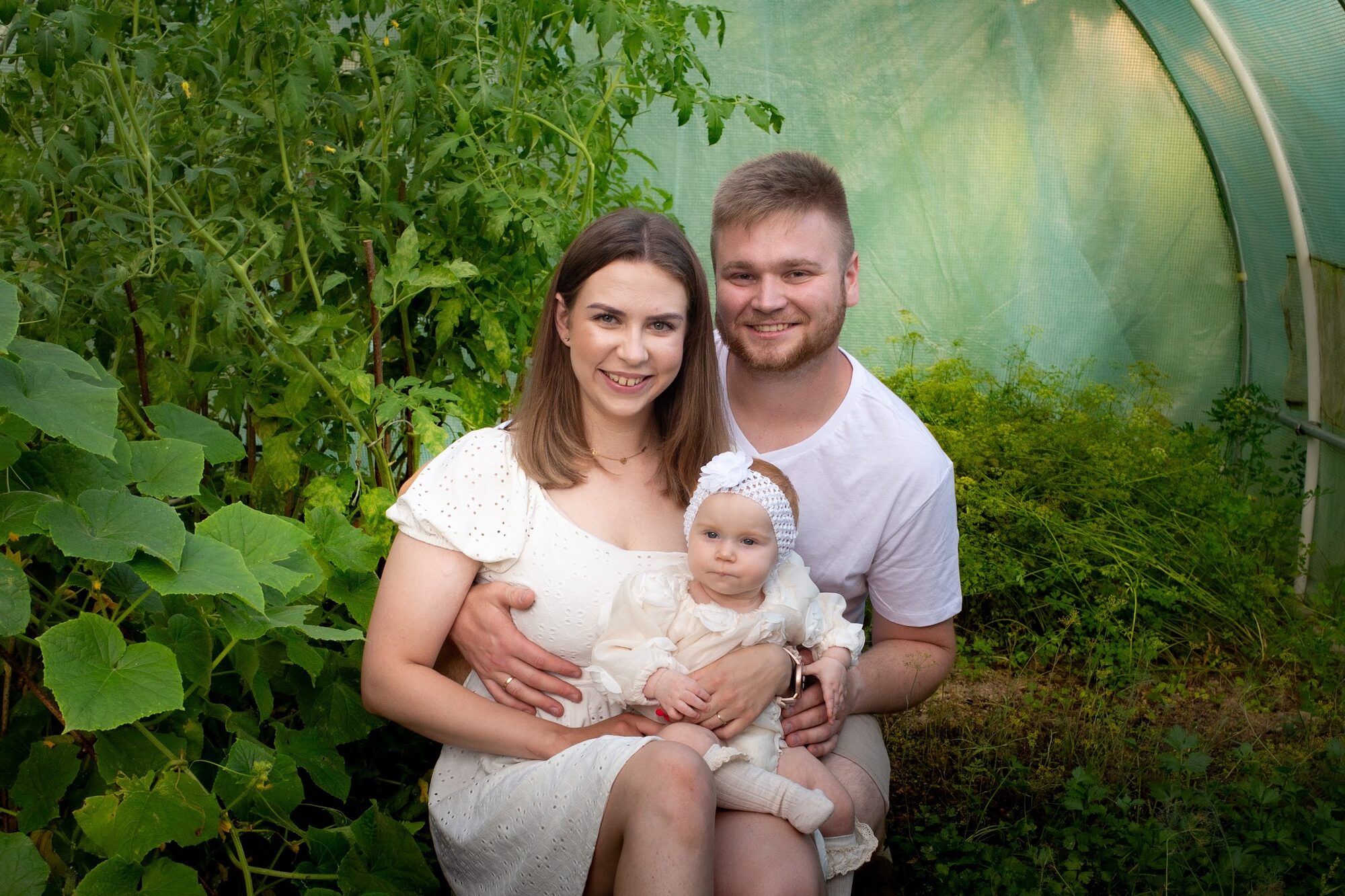 Parents with their baby in a polytunnel