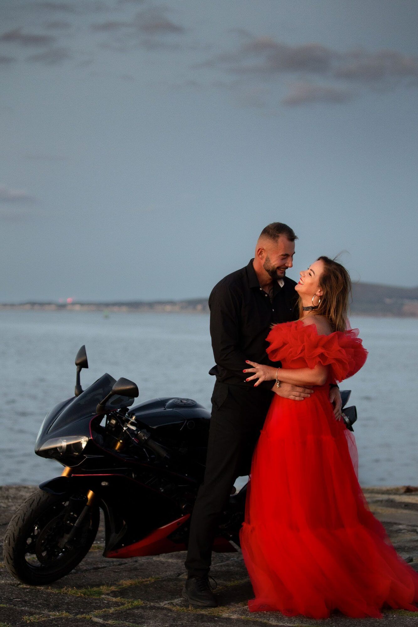 Couple beside a motorbike by the sea
