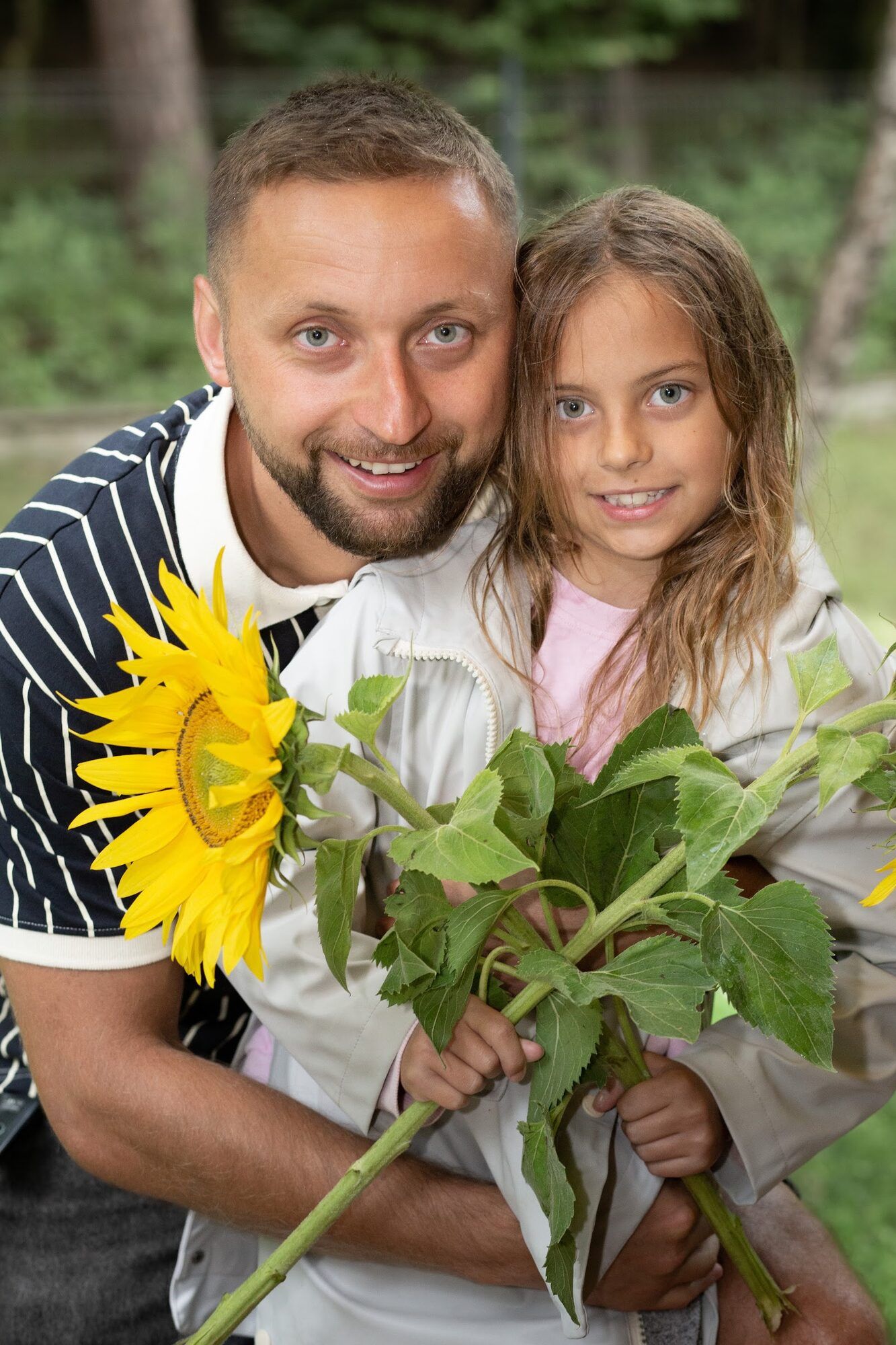 Father with his daughter and sunflowers